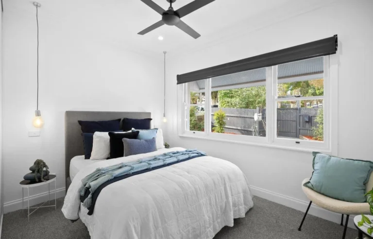 Cozy bedroom with window view and modern decor.