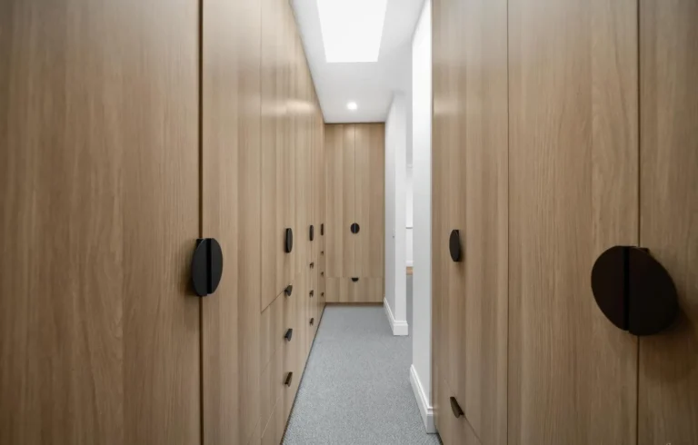 Modern walk-in closet with wooden cabinets.