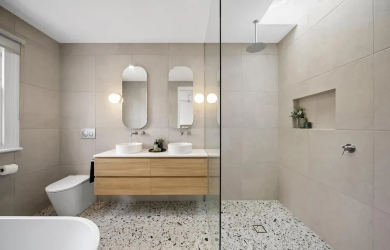 Modern bathroom with dual sinks and shower.
