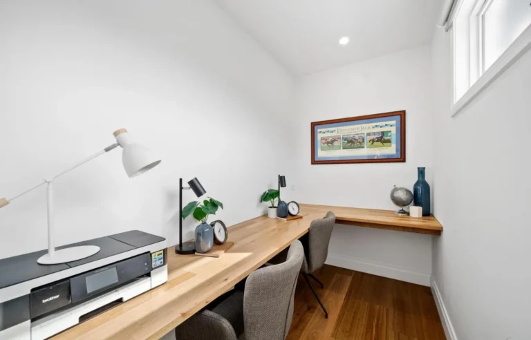 Minimalist home office with wooden desk and lamps.