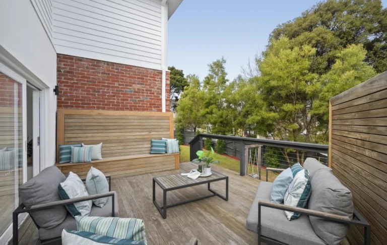 Cozy patio with seating and greenery view.
