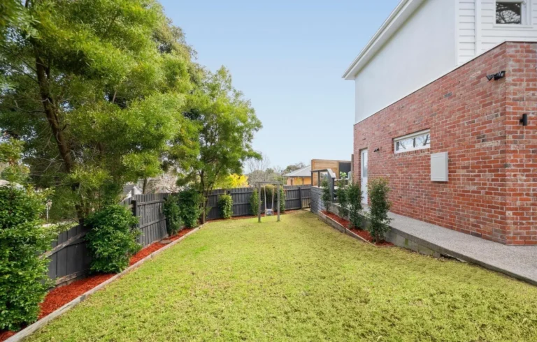 Backyard with grass, fence, and trees