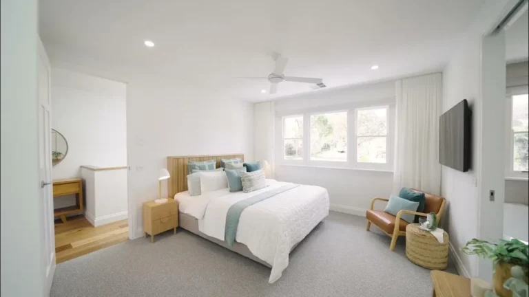 Modern bedroom with large windows and cozy decor.